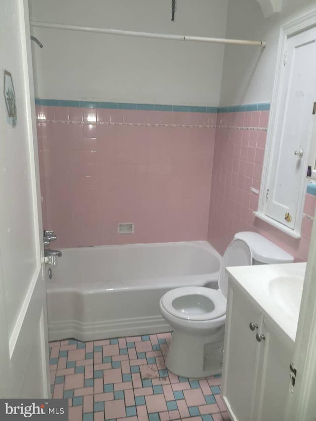 5137 D St, Philadelphia, PA 19120 - full bath featuring toilet, tile patterned floors, vanity, bathing tub / shower combination, and tile walls