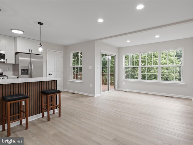 14282 Newbern Loop, Gainesville, VA 20155 - kitchen featuring stainless steel appliances, light countertops, white cabinets, a breakfast bar area, and baseboards