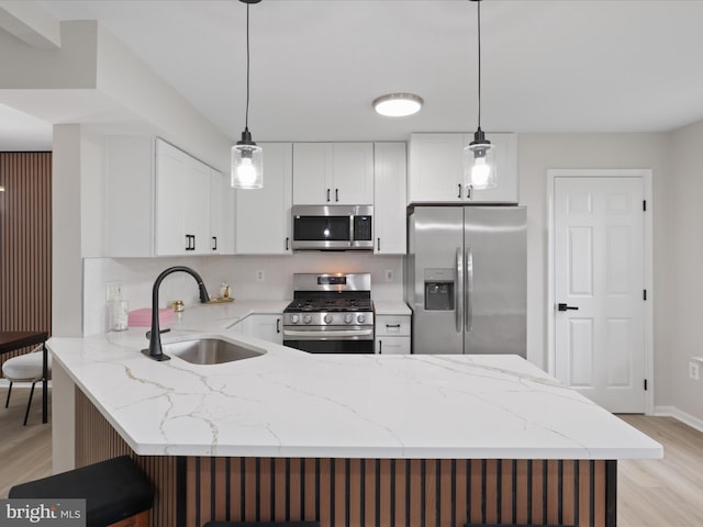 14282 Newbern Loop, Gainesville, VA 20155 - kitchen with appliances with stainless steel finishes, a sink, a peninsula, light wood-style floors, and light stone countertops