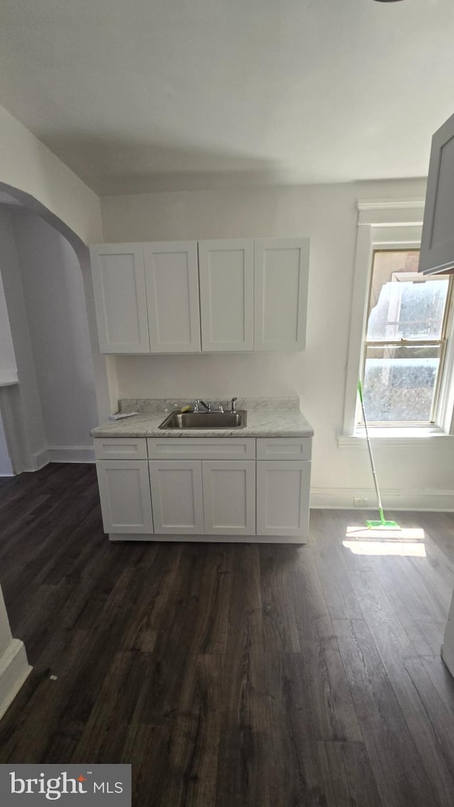 2564 N Reese St, Philadelphia, PA 19133 - kitchen featuring a sink, arched walkways, dark wood finished floors, light countertops, and baseboards