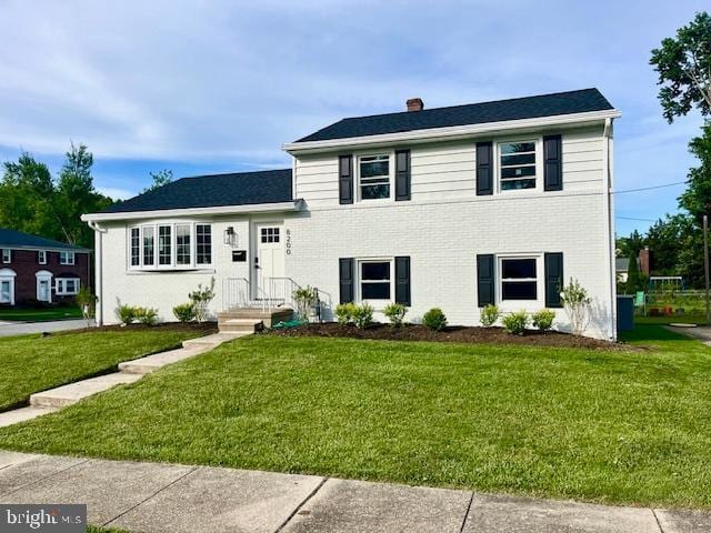 8200 Boman Ct, Baltimore, MD 21204 - split level home with a chimney, a front lawn, and brick siding