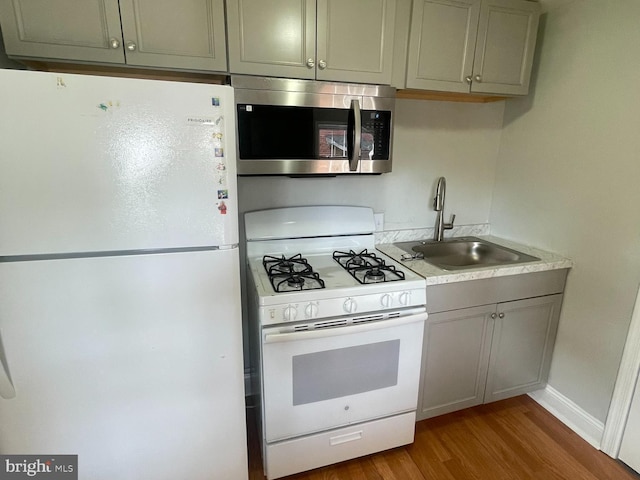 8528 Chestnut Oak, Baltimore, MD 21234 - kitchen featuring white appliances, a sink, wood finished floors, light countertops, and baseboards
