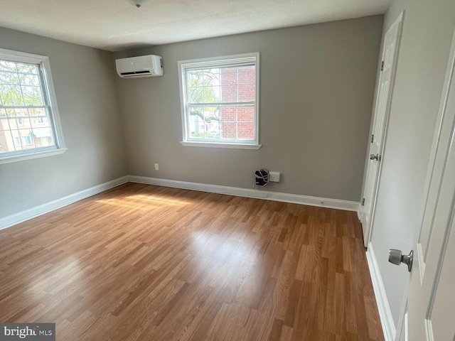 8528 Chestnut Oak, Baltimore, MD 21234 - unfurnished room featuring a wall unit AC, healthy amount of natural light, and wood finished floors