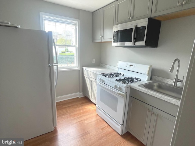 8528 Chestnut Oak, Baltimore, MD 21234 - kitchen featuring white appliances, a sink, light wood finished floors, and light countertops