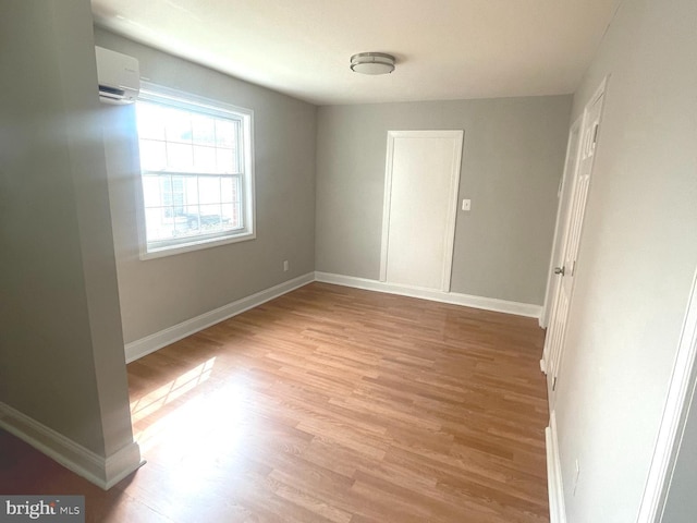 8528 Chestnut Oak, Baltimore, MD 21234 - unfurnished room with an AC wall unit, light wood finished floors, and baseboards