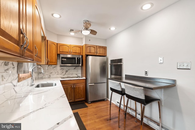 559 Schenely Ave, King Of Prussia, PA 19406 - kitchen featuring stainless steel appliances, a baseboard heating unit, brown cabinets, a ceiling fan, and tasteful backsplash