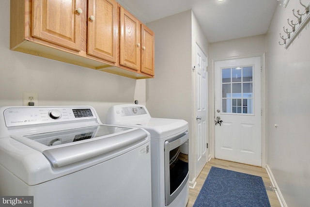2119 Saint Heather Ln, Gambrills, MD 21054 - washroom featuring separate washer and dryer, cabinet space, light wood-style flooring, and baseboards