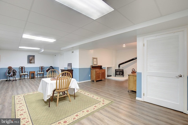 2119 Saint Heather Ln, Gambrills, MD 21054 - dining space with light wood-style flooring, baseboards, a drop ceiling, and a wood stove
