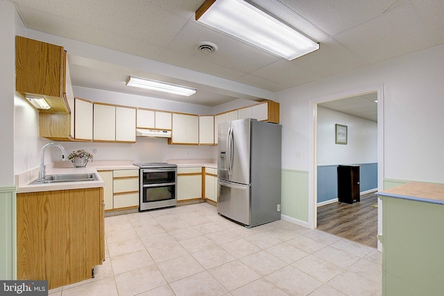 2119 Saint Heather Ln, Gambrills, MD 21054 - kitchen featuring appliances with stainless steel finishes, a sink, light countertops, under cabinet range hood, and a wainscoted wall