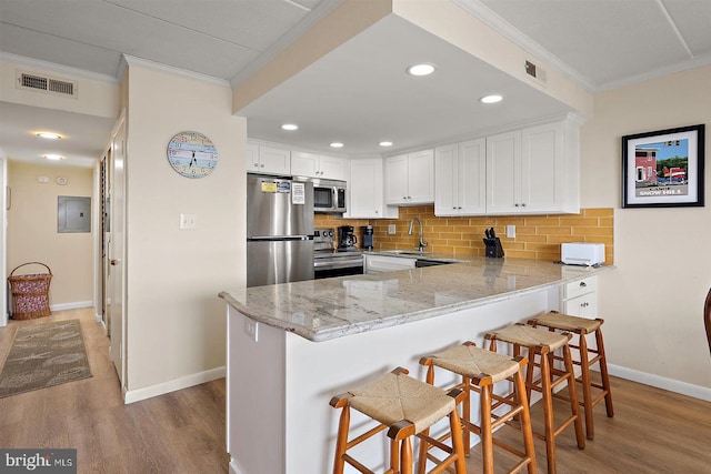 3801 Atlantic Ave Unit 517, Ocean City, MD 21842 - kitchen featuring appliances with stainless steel finishes, crown molding, a peninsula, wood finished floors, and baseboards