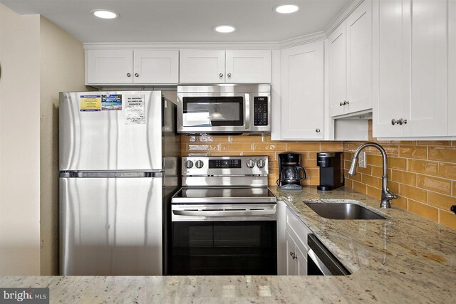 3801 Atlantic Ave Unit 517, Ocean City, MD 21842 - kitchen with appliances with stainless steel finishes, a sink, white cabinetry, light stone countertops, and backsplash