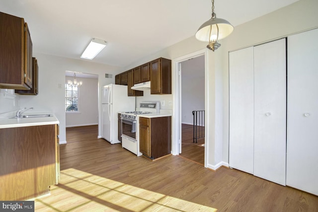 1 Ridge Heights Ct, Gaithersburg, MD 20879 - kitchen with white appliances, under cabinet range hood, a sink, light wood-style flooring, and light countertops