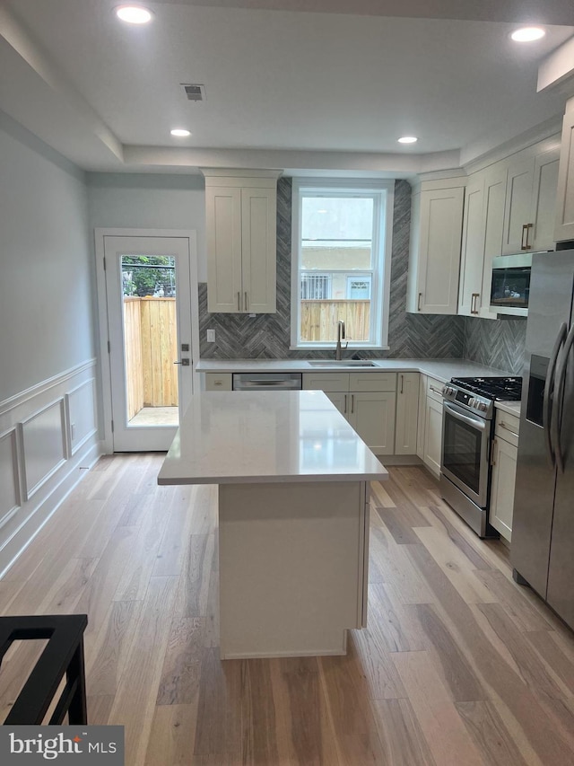 2039 S Cleveland St, Philadelphia, PA 19145 - kitchen featuring stainless steel appliances, a sink, plenty of natural light, light countertops, and wainscoting