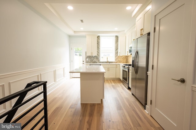 2039 S Cleveland St, Philadelphia, PA 19145 - kitchen with appliances with stainless steel finishes, a sink, light wood finished floors, decorative backsplash, and wainscoting