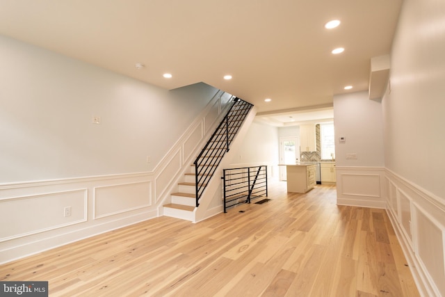 2039 S Cleveland St, Philadelphia, PA 19145 - unfurnished living room with a decorative wall, light wood-type flooring, recessed lighting, stairway, and wainscoting