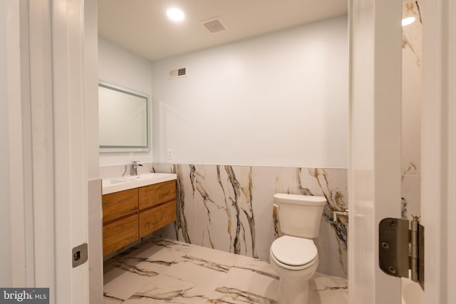 2039 S Cleveland St, Philadelphia, PA 19145 - bathroom with marble tiled flooring, toilet, vanity, a wainscoted wall, and tile walls