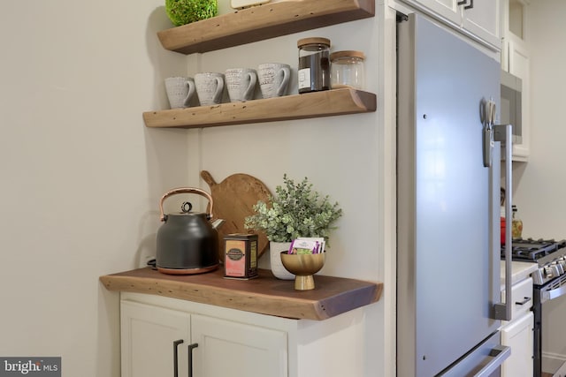 30 N Marshall St, Lancaster, PA 17602 - detailed view of open shelves, freestanding refrigerator, wooden counters, white cabinets, and stainless steel gas range oven