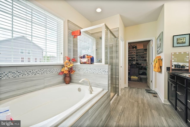 5544 Old Colony Ct, White Plains, MD 20695 - full bathroom featuring a bath, a stall shower, vanity, a spacious closet, and baseboards