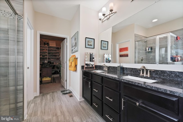 5544 Old Colony Ct, White Plains, MD 20695 - bathroom featuring double vanity, a stall shower, a spacious closet, and baseboards