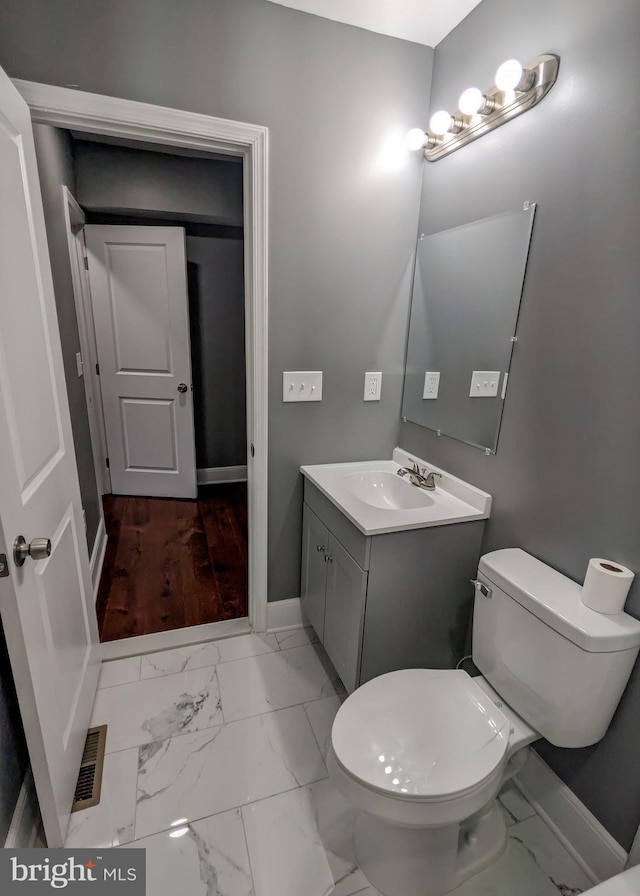 1512 W Pratt St, Baltimore, MD 21223 - bathroom with vanity, marble look tiles, baseboards, and toilet
