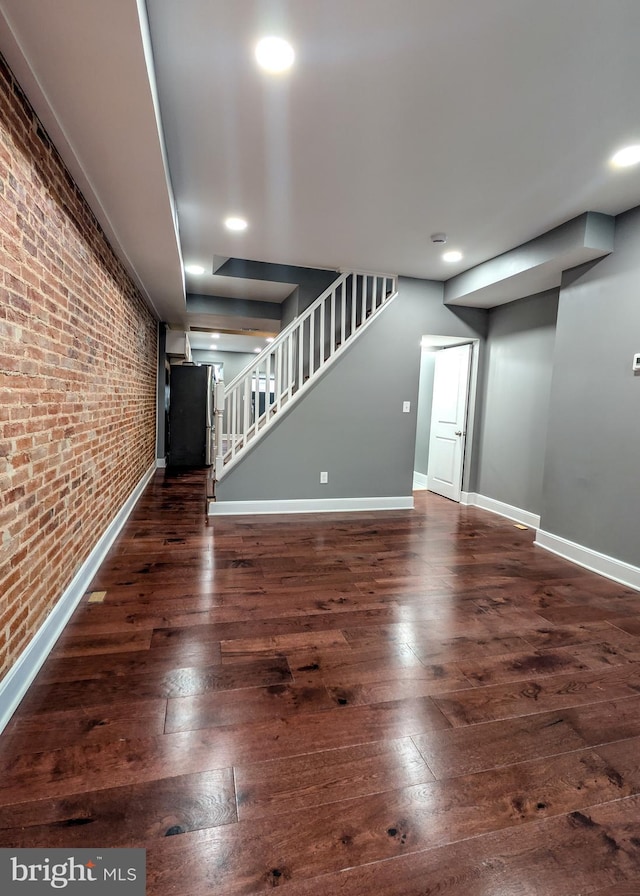 1512 W Pratt St, Baltimore, MD 21223 - unfurnished living room with brick wall, stairs, wood-type flooring, baseboards, and recessed lighting
