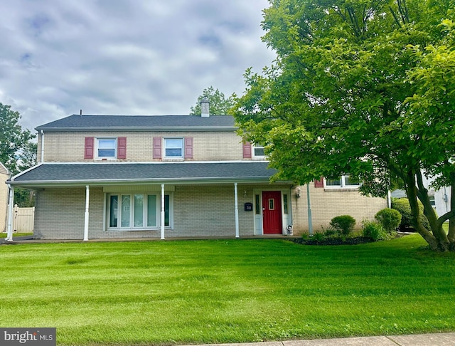 713 Worthington Dr, Warminster, PA 18974 - view of front facade with a front yard, brick siding, covered porch, and a chimney