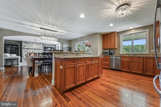 205 Mallard Dr, Stevensville, MD 21666 - kitchen featuring dishwasher, wood-type flooring, open floor plan, brown cabinetry, and a sink