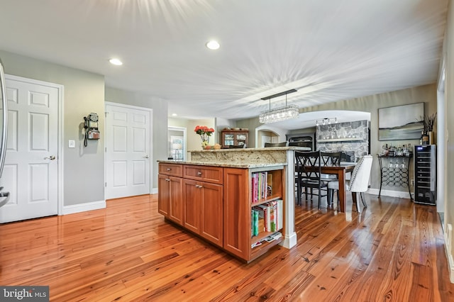 205 Mallard Dr, Stevensville, MD 21666 - kitchen with brown cabinets, light wood-style flooring, beverage cooler, light stone countertops, and recessed lighting
