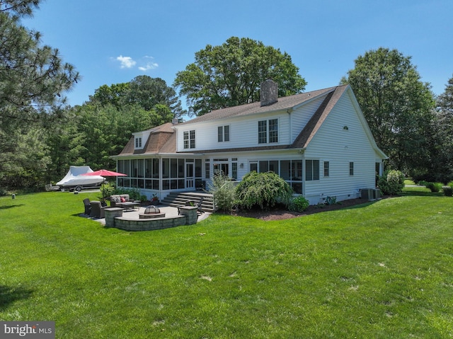 205 Mallard Dr, Stevensville, MD 21666 - rear view of property with a sunroom, an outdoor fire pit, a chimney, and a lawn