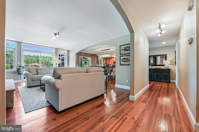 205 Mallard Dr, Stevensville, MD 21666 - living area with arched walkways, wood-type flooring, baseboards, and a chandelier