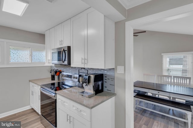 15 Wildflower Rd, Levittown, PA 19057 - kitchen featuring appliances with stainless steel finishes, light wood-style floors, backsplash, and white cabinets