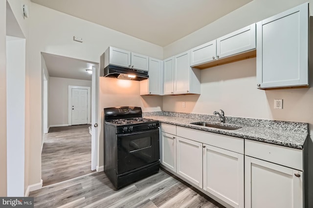 118 N Hilton St, Baltimore, MD 21229 - kitchen with gas stove, under cabinet range hood, a sink, light wood-style flooring, and light stone countertops