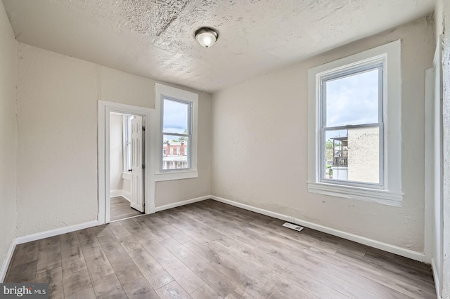 118 N Hilton St, Baltimore, MD 21229 - empty room featuring baseboards, wood finished floors, and a textured ceiling