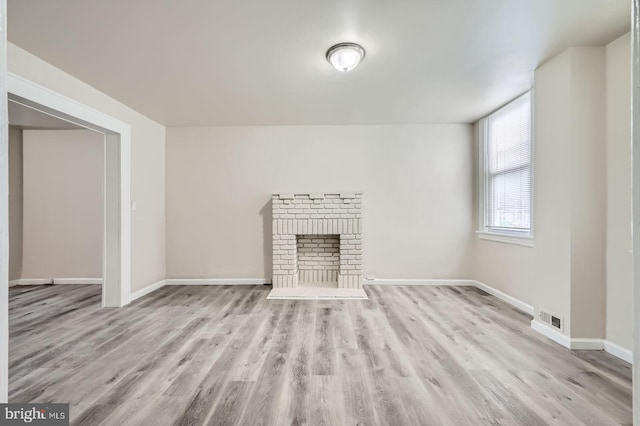 118 N Hilton St, Baltimore, MD 21229 - unfurnished living room featuring wood finished floors, baseboards, and a fireplace