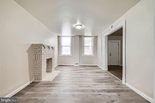 118 N Hilton St, Baltimore, MD 21229 - unfurnished living room featuring a brick fireplace, wood finished floors, and baseboards