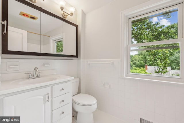 8404 Galveston Rd, Silver Spring, MD 20910 - bathroom featuring plenty of natural light, tile walls, toilet, vanity, and a wainscoted wall