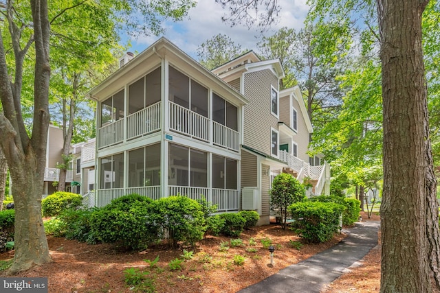 33340 Timberview Ct Unit 21003, Bethany Beach, DE 19930 - view of home's exterior with a sunroom and a chimney