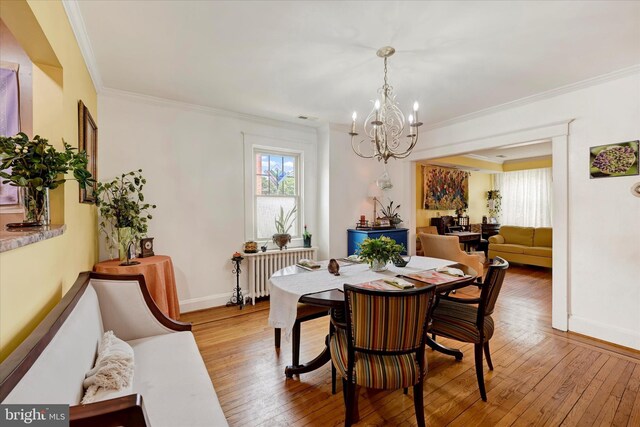 4224 Evans Chapel Rd, Baltimore, MD 21211 - dining space featuring radiator heating unit, a chandelier, plenty of natural light, wood-type flooring, and ornamental molding