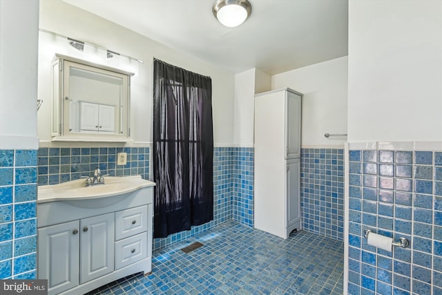 3603 6th St, Baltimore, MD 21225 - bathroom with tile walls, a wainscoted wall, tile patterned flooring, and vanity