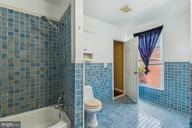 3603 6th St, Baltimore, MD 21225 - bathroom featuring tile walls, toilet, a wainscoted wall, shower / tub combination, and tile patterned floors