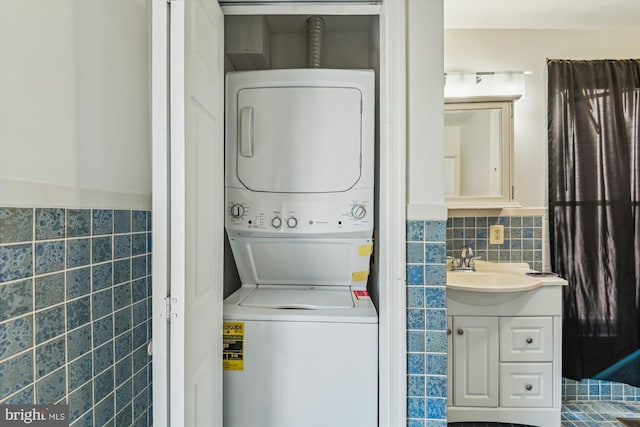 3603 6th St, Baltimore, MD 21225 - laundry area with stacked washer / drying machine, tile walls, and wainscoting