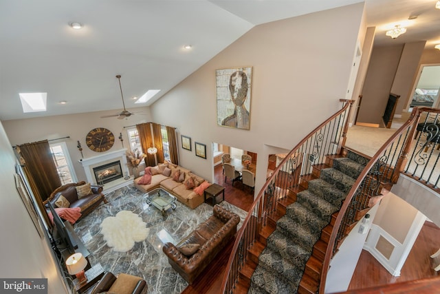 60 Sleepy Hollow Dr, Tabernacle, NJ 08088 - living area with a glass covered fireplace, a skylight, lofted ceiling, wood finished floors, and stairs