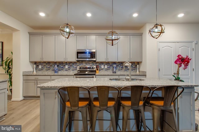 16600 Tortola Dr, Accokeek, MD 20607 - kitchen with stainless steel appliances, a sink, decorative backsplash, light wood-style flooring, and recessed lighting