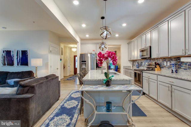 16600 Tortola Dr, Accokeek, MD 20607 - kitchen featuring stainless steel appliances, open floor plan, a sink, light wood-style flooring, and recessed lighting