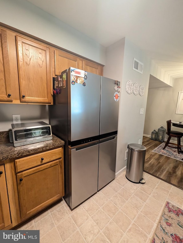 513 Dakemich Ct, Enola, PA 17025 - kitchen featuring freestanding refrigerator, dark countertops, baseboards, and brown cabinetry
