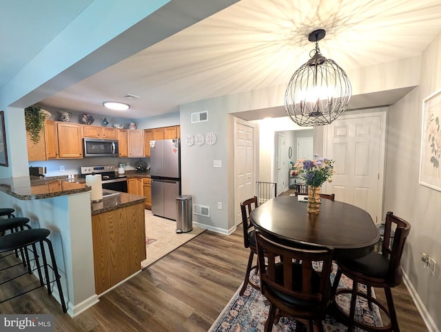513 Dakemich Ct, Enola, PA 17025 - kitchen featuring appliances with stainless steel finishes, a peninsula, wood finished floors, and baseboards