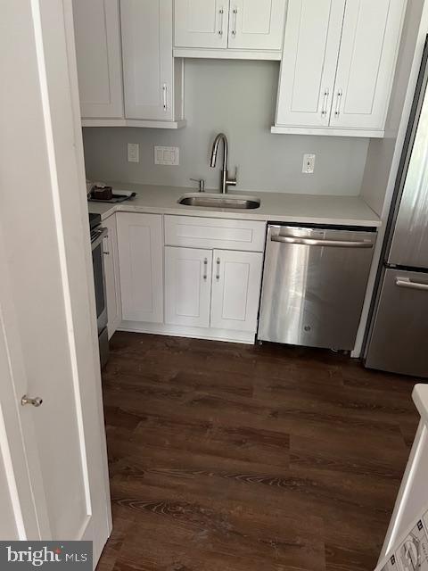 6301 Stevenson Ave Unit 604, Alexandria, VA 22304 - kitchen with a sink, stainless steel appliances, dark wood-style floors, white cabinets, and light countertops
