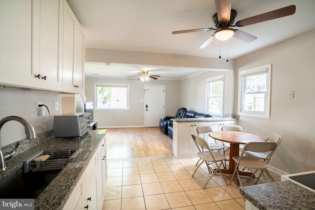 143 Baker St, Manassas Park, VA 20111 - kitchen featuring a sink, a ceiling fan, baseboards, white cabinets, and open floor plan
