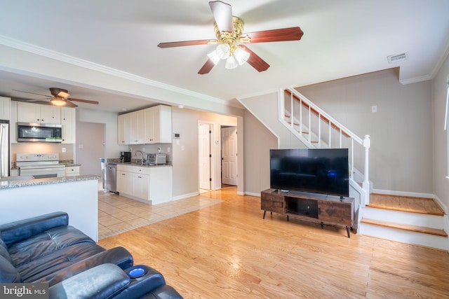 143 Baker St, Manassas Park, VA 20111 - living area with ceiling fan, stairs, crown molding, light wood finished floors, and baseboards