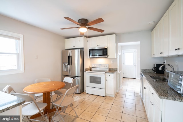 143 Baker St, Manassas Park, VA 20111 - kitchen with stainless steel appliances, a sink, ceiling fan, light tile patterned floors, and white cabinets